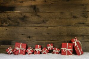 Professional Photo Organizer. Wooden rustic country background with red winter holiday presents.