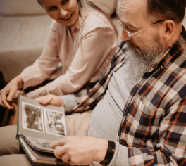 Man and woman sitting looking at photo album