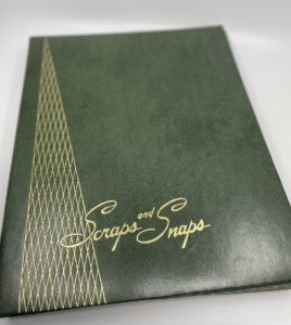 old fashioned green scrapbook on white seamless with gold lettering