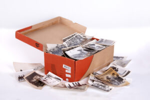 Shoebox overflowing with print photos